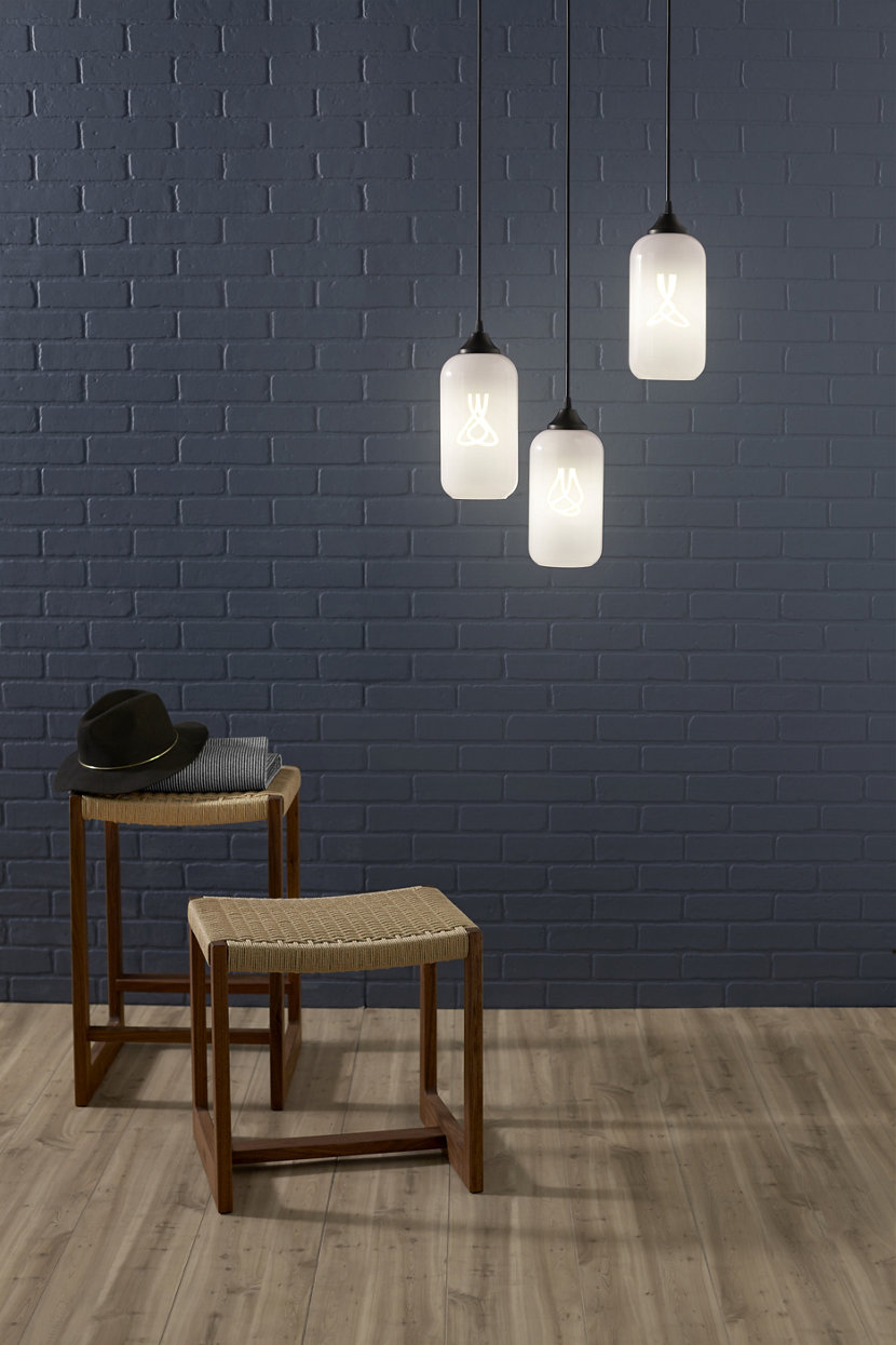 white glass pendant lights against blue brick wall