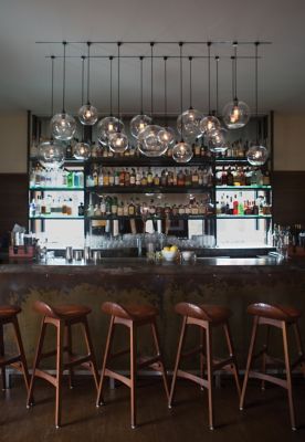 Custom Crystal Solitaire Pendants Hang Above Bar in the Roundhouse